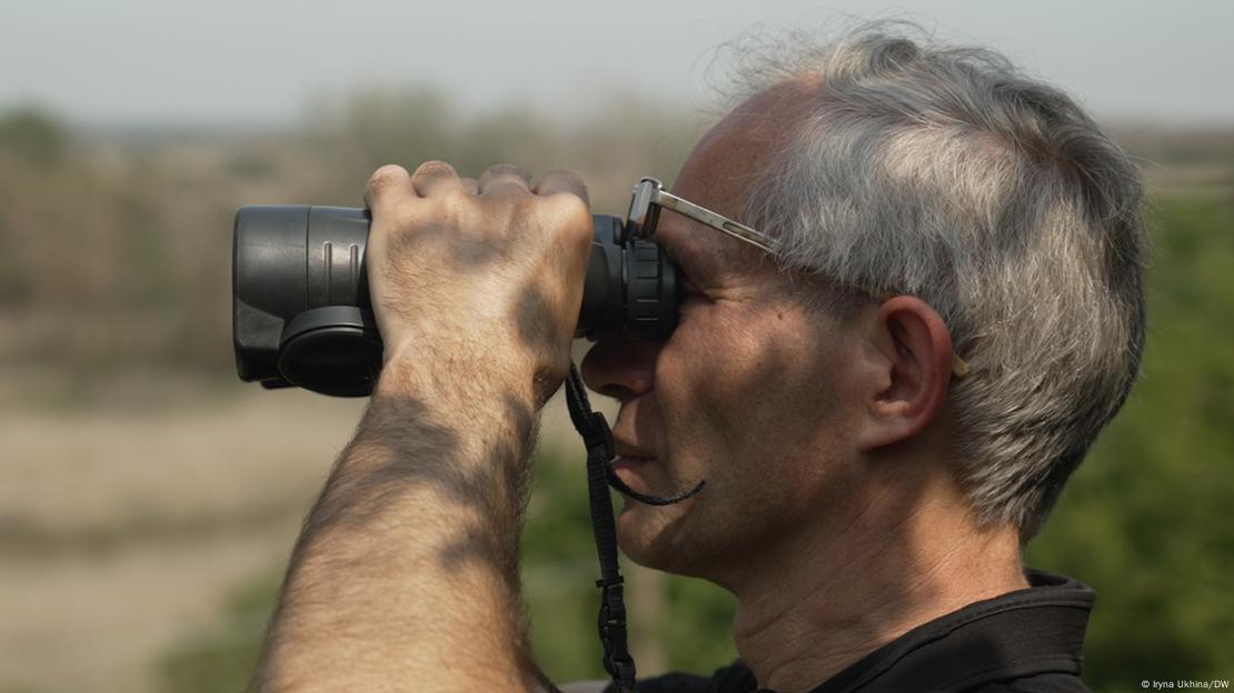 Еколог Вадим Манюк дивиться у бінокль