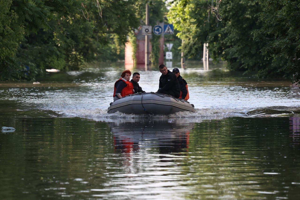 Люди плывут на лодке по затопленному Херсону