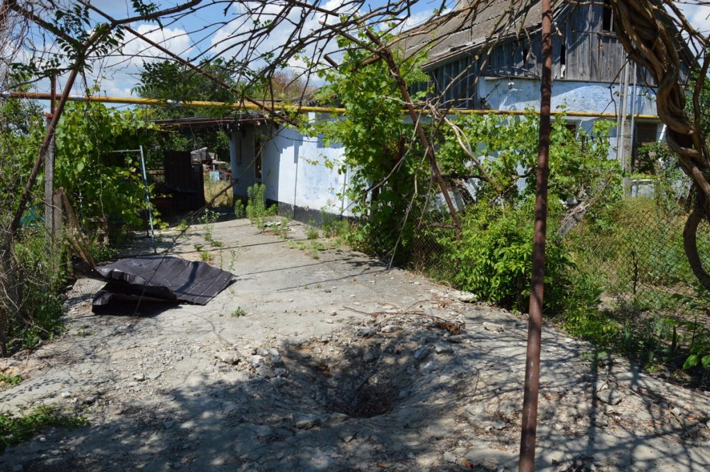 воронка от снаряда во дворе дома